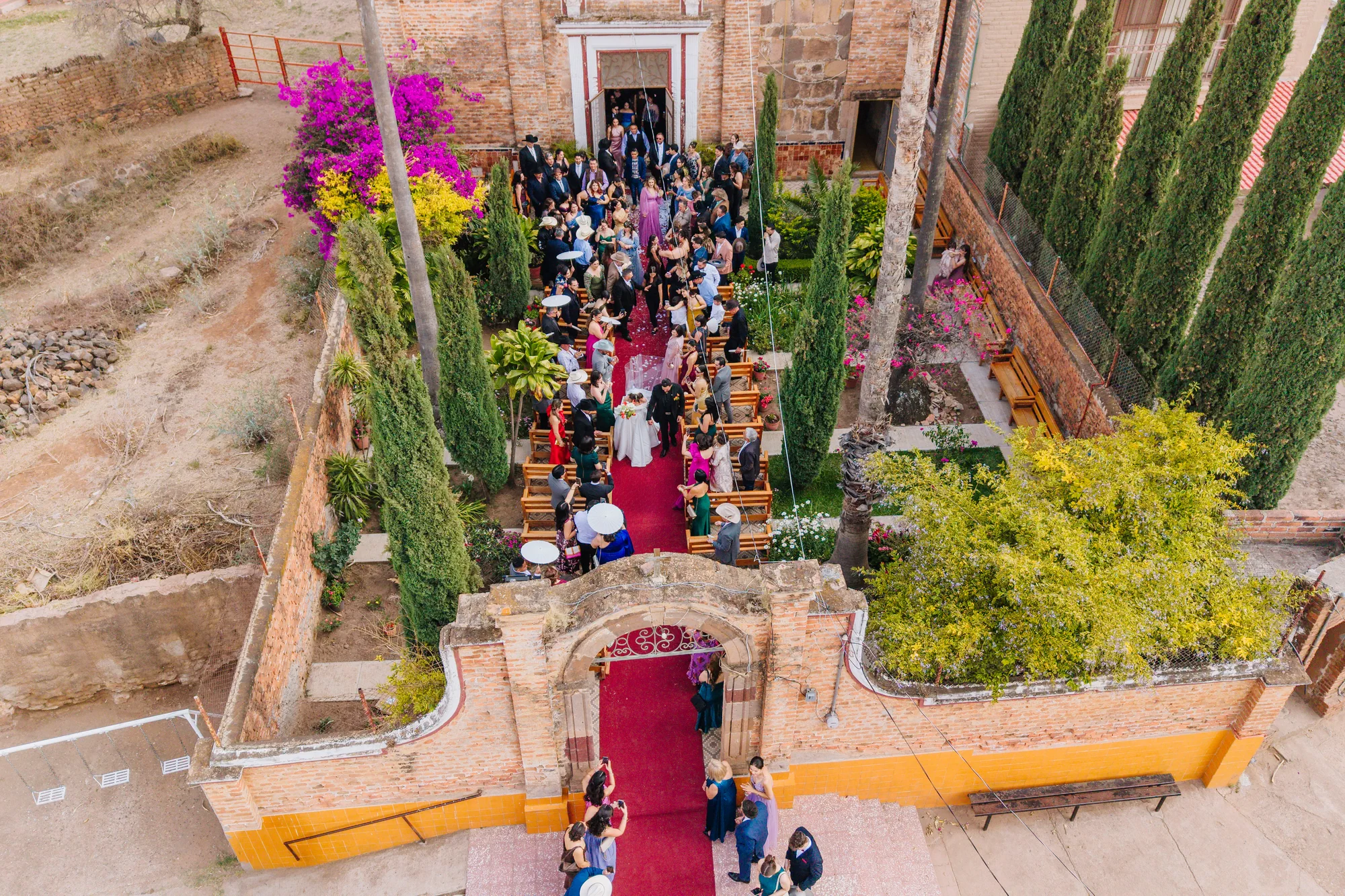 Vista aérea de los novios e invitados al salir de la ceremonia