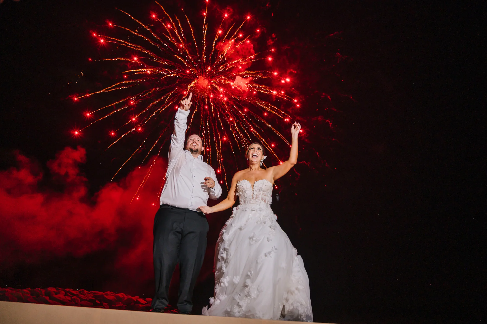 Novios celebrando bajo los fuegos artificiales