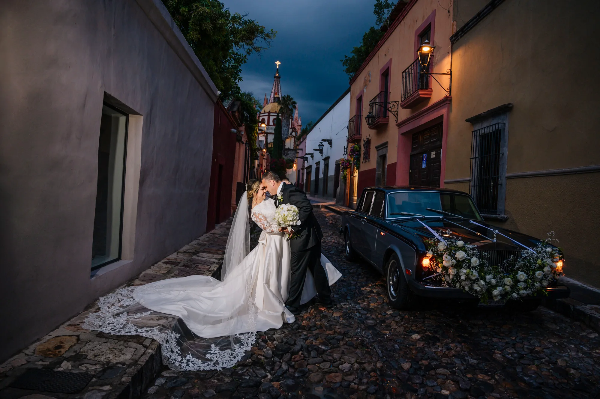 Novios junto a un automóvil clásico en una calle de San Miguel de Allende
