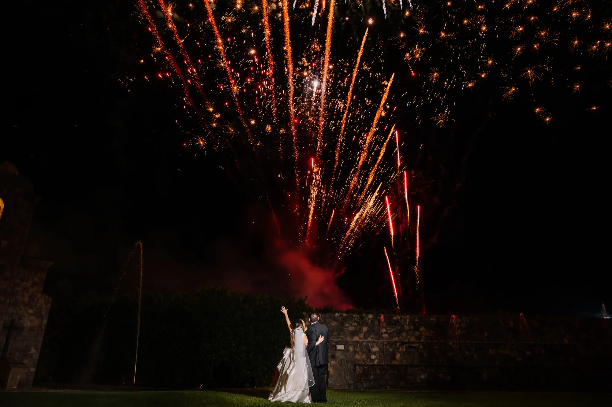 Novios celebrando su boda bajo fuegos artificiales