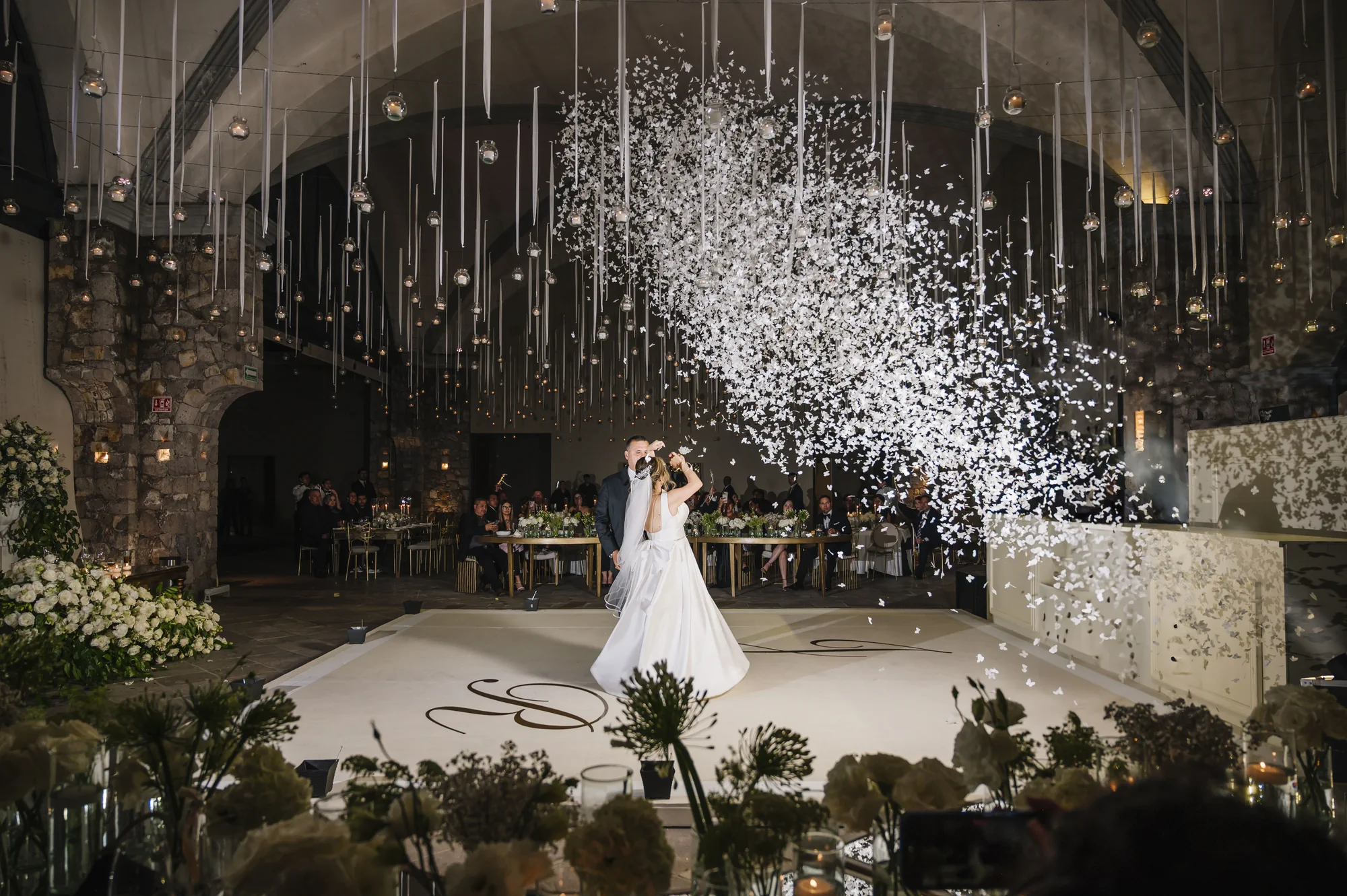 Novios bailando su vals rodeados de confeti durante la recepción