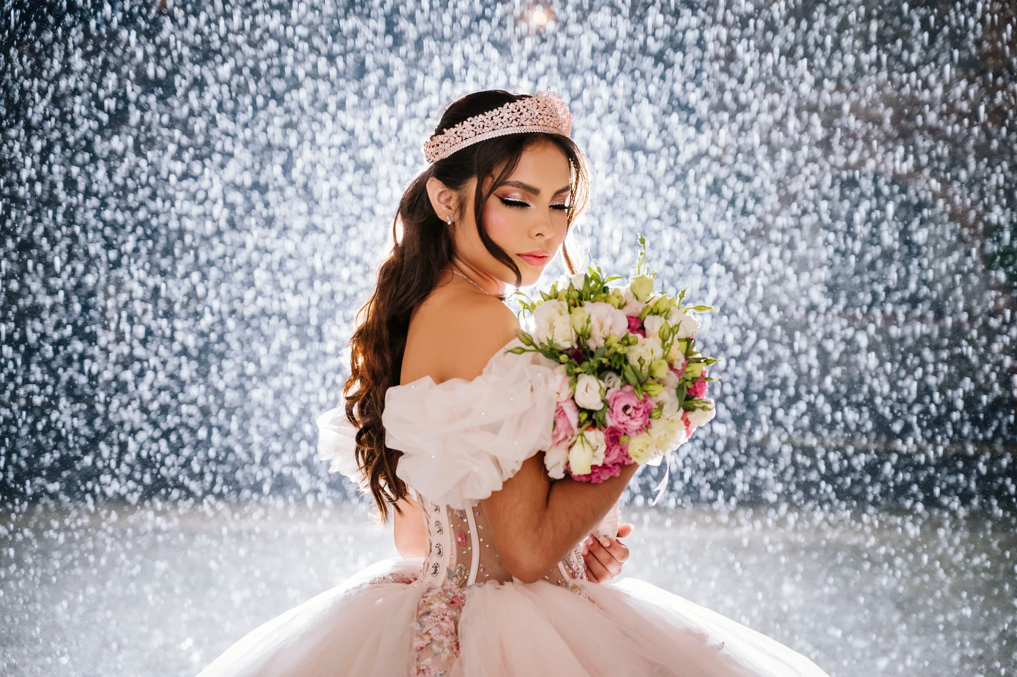 Quinceañera sosteniendo un ramo de flores frente a la lluvia