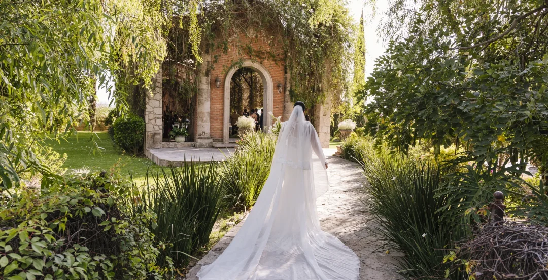 Novia caminando por los jardines hacia la ceremonia