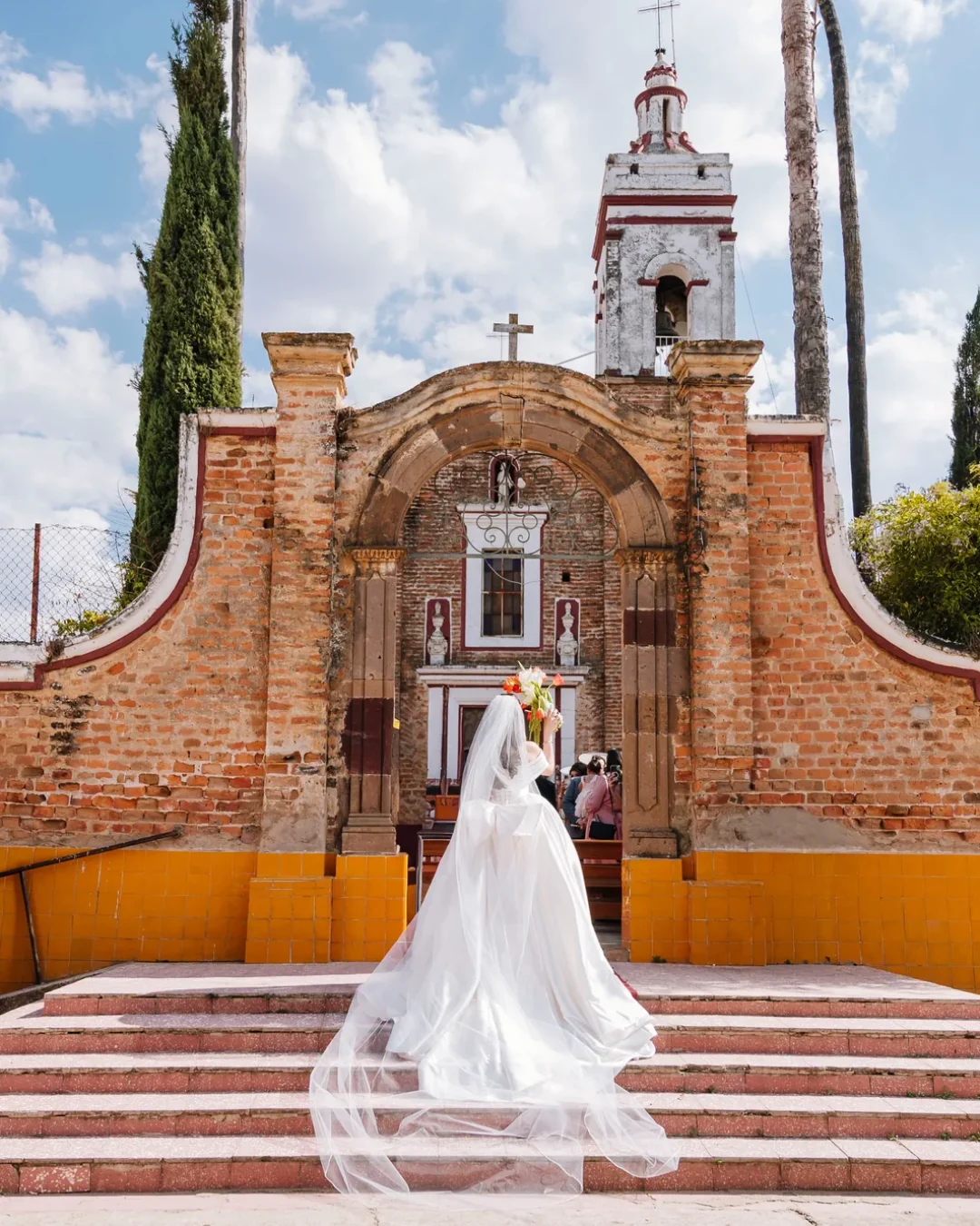 Novia con el velo extendido frente al templo