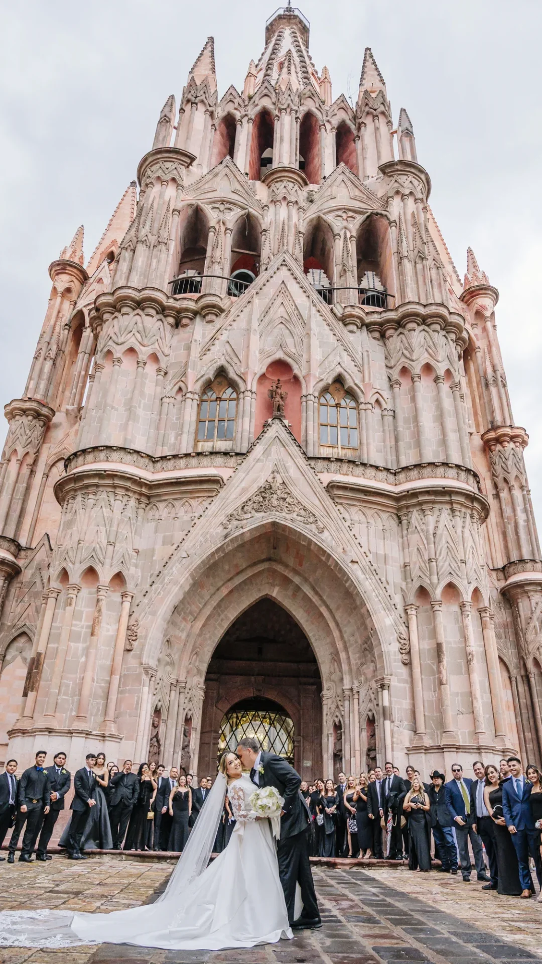 Novios celebrando con sus invitados frente a una iglesia de San Miguel de Allende