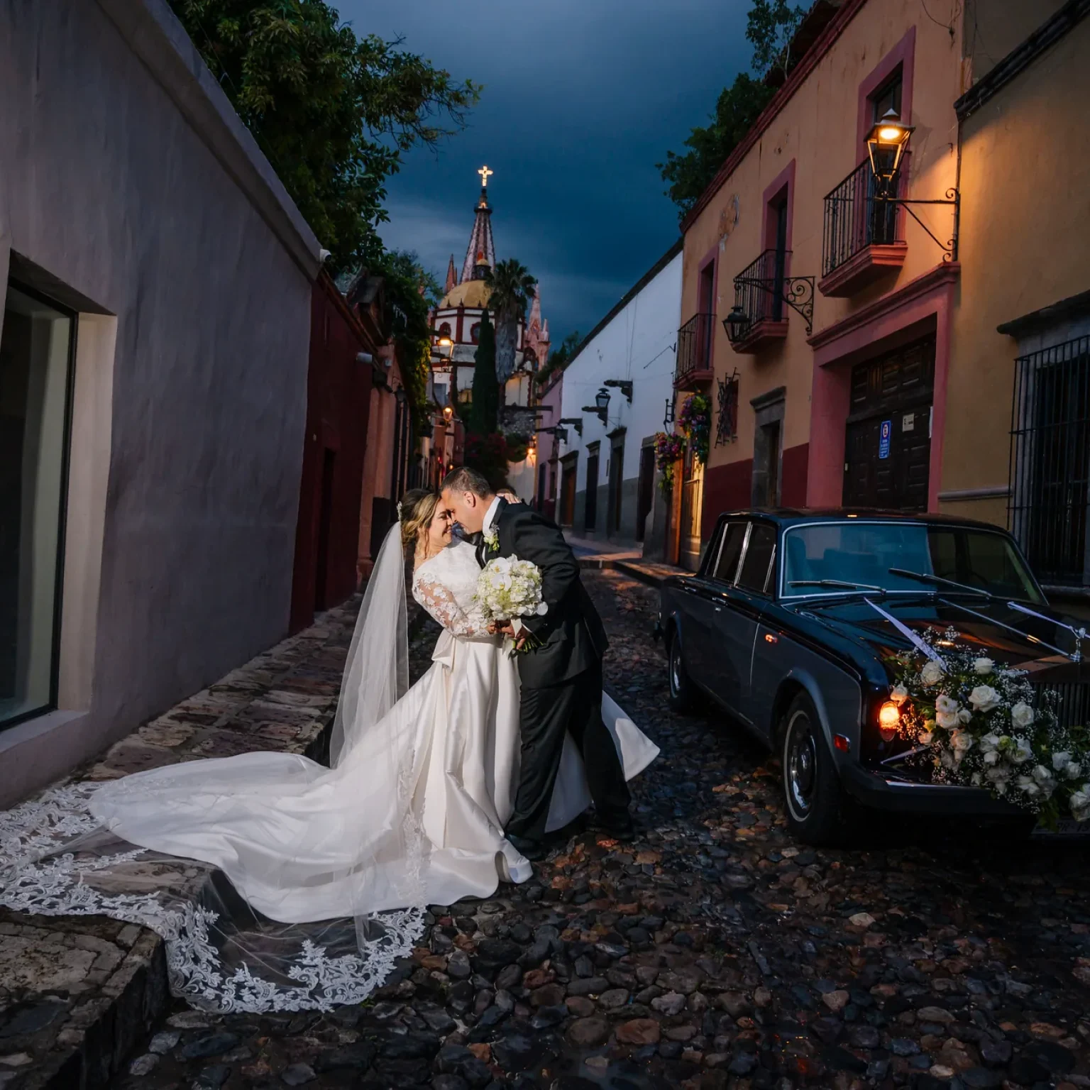 Novios junto a un automóvil clásico en una calle de San Miguel de Allende